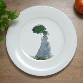 White plate with an impressionist-style illustration of a woman holding a green umbrella