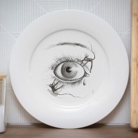 White plate with a black-and-white sketch of a human eye